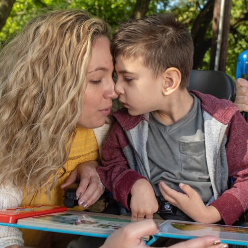 Mother and son touch faces.