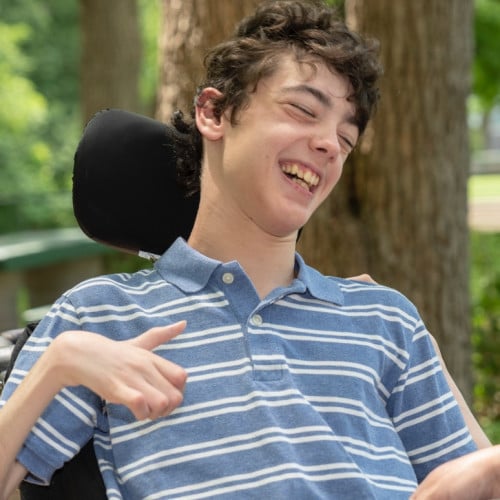 Teenager smiling in wheelchair.